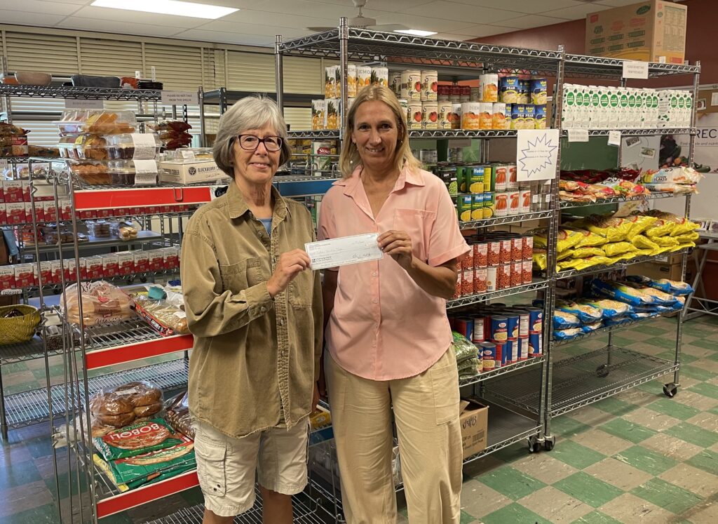 Judy Quigley presents an award check for $7,000 to Renee Spear, Executive Director of Catholic Charities Tompkins/Tioga